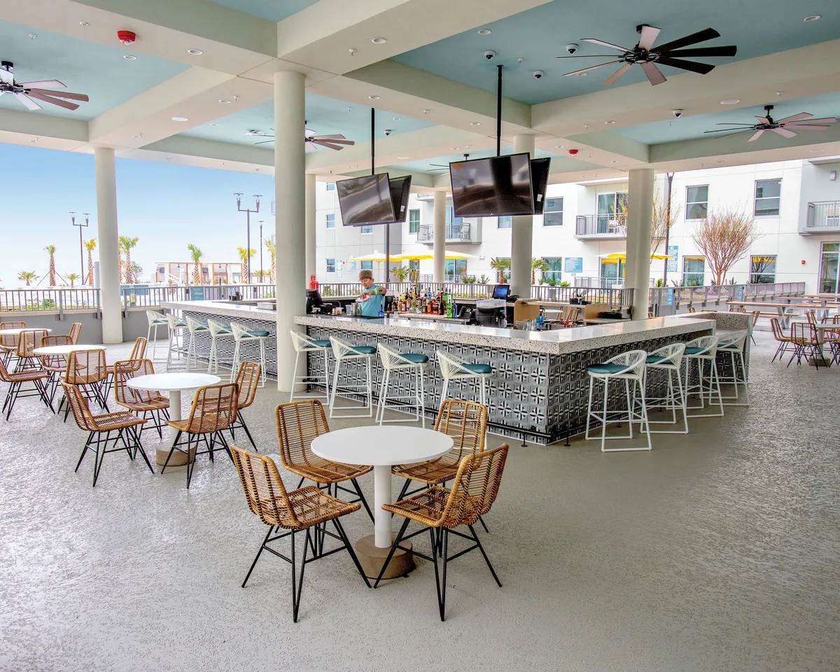 This image showcases a cozy indoor bar area with thoughtfully arranged seating and a view of the outdoors. The setup invites guests to relax, socialize, or enjoy a casual drink, with the outdoor view hinting at direct access to fresh air and nature, reminiscent of a balcony or terrace experience.